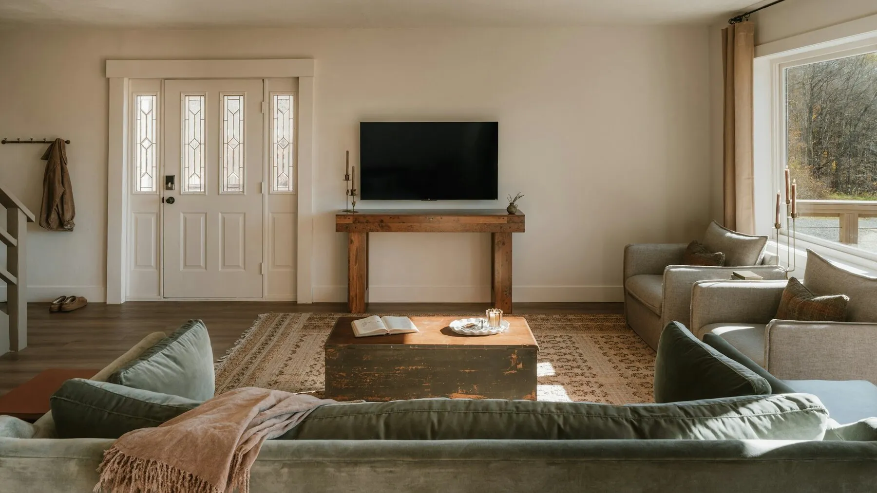 Wohnzimmer mit Sofa, Couchtisch und wandmontiertem Fernseher